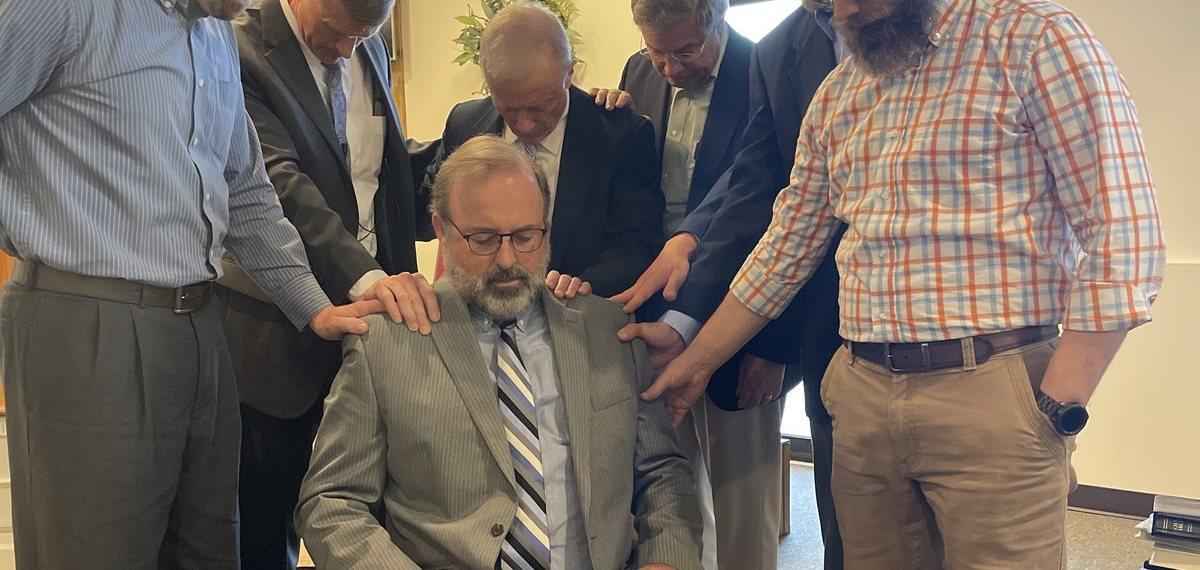 The elders praying with the laying on of hands at an ordination service